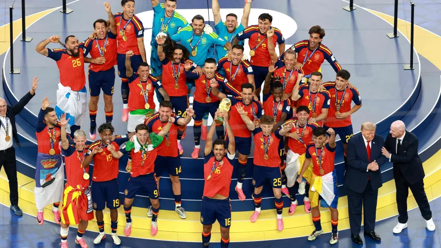 Jogadores da Espanha levantam o troféu da Copa do Mundo, com Trump e Infantino ao lado Imagem: ELSA/Getty Images via AFP