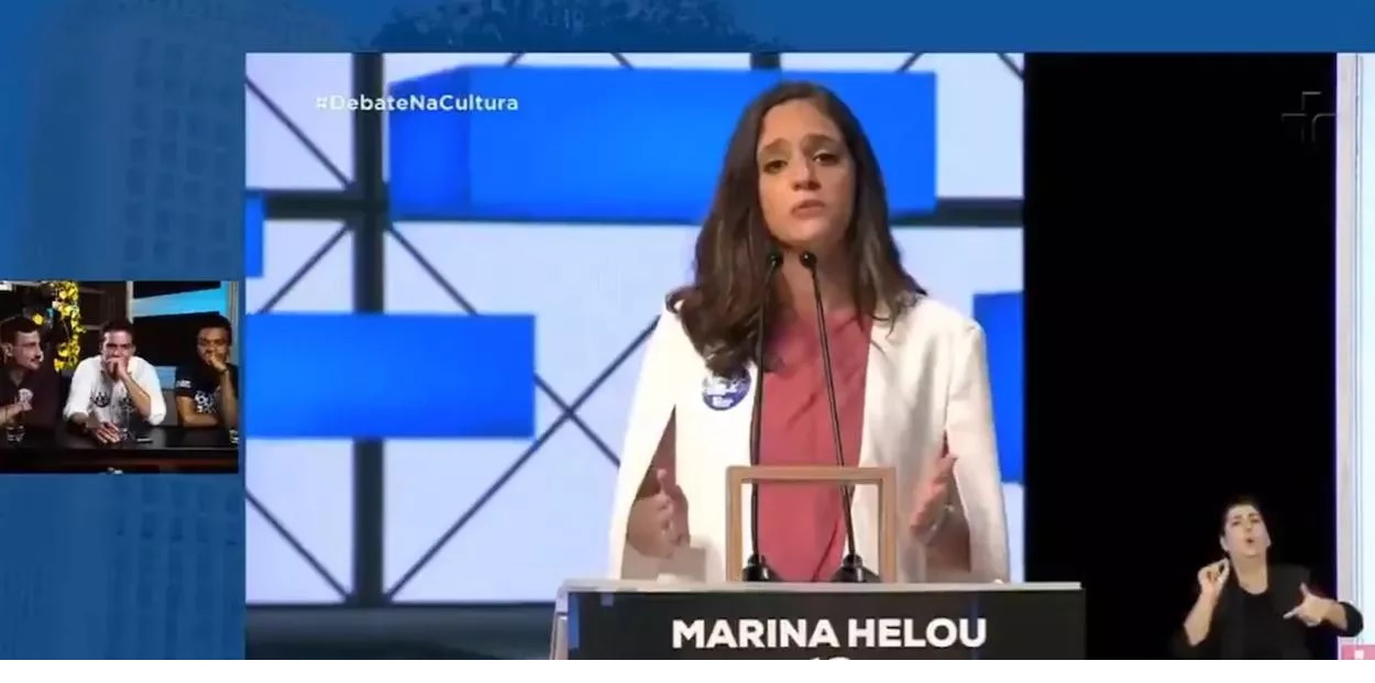 Candidato a vereador é flagrado fazendo gesto obsceno para candidata à prefeita